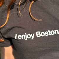 closeup photo of a woman wearing black unisex t-shirt with the words i enjoy boston sports in white text