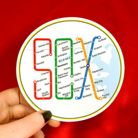 person holding 4" round sticker of design of the boston MBTA map in the shape of the word SOX