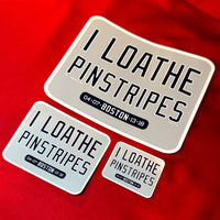 photo of 3 sizes of waterproof vinyl sticker of I Loathe Pinstripes-The Red Seat grey design with boston world series wins Yankees Suck with a ruler on red background