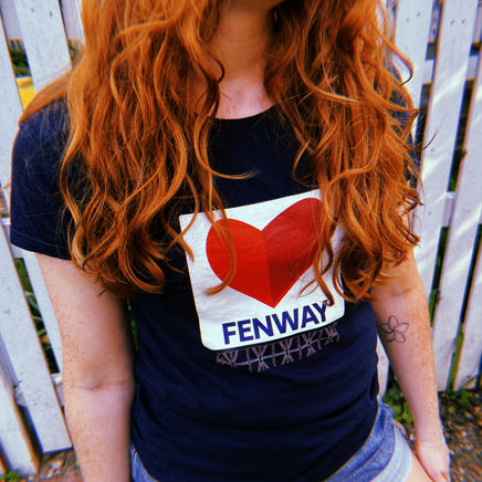 photo of woman wearing navy blue women's t-shirt with the boston fenway citgo sign in the shape of a heart