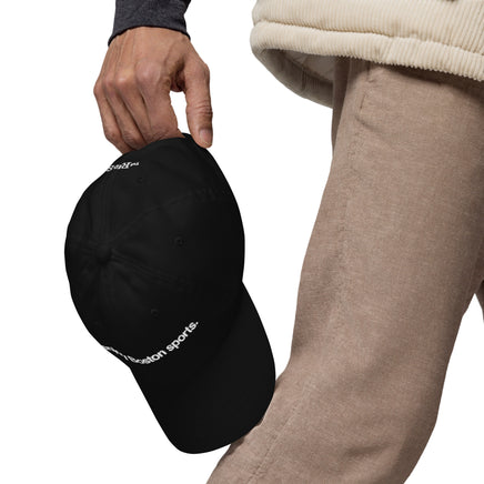 man holding black baseball cap with "i enjoy boston sports" embroidered in white helvetica font
