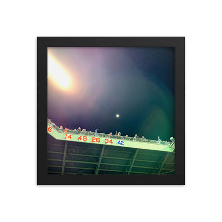 photo of right field fenway park at night with retired red sox numbers in a black frame