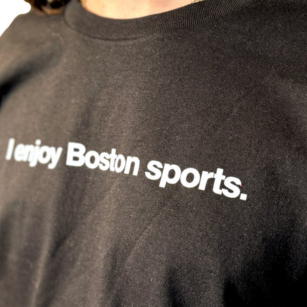 photo of a black unisex t-shirt with the words i enjoy boston sports in white text