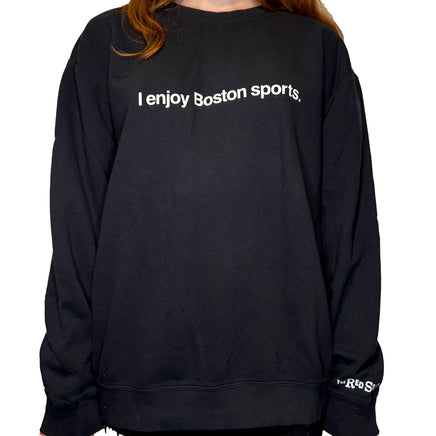 woman wearing black unisex crewneck sweatshirt with the words i enjoy boston sports in white on the front