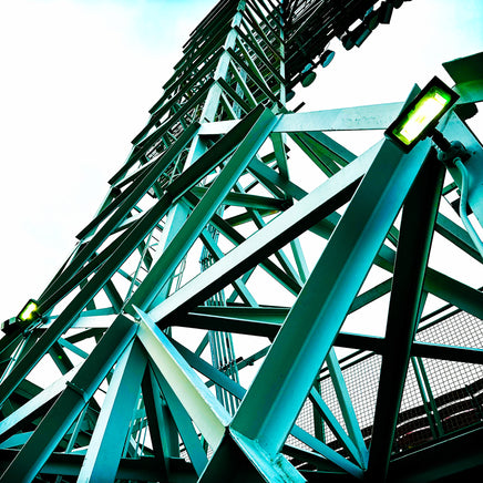 photograph of a boston red sox fenway park light tower looking up with green metal and a light sky.