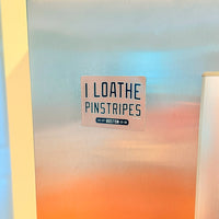 Refrigerator magnet with text 'I LOATHE PINSTRIPES' on a stainless steel fridge