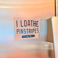 Refrigerator magnet with text 'I LOATHE PINSTRIPES' on a stainless steel fridge