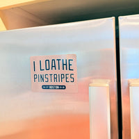 Refrigerator magnet with text 'I LOATHE PINSTRIPES' on a stainless steel fridge