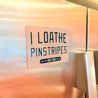 Refrigerator magnet with text 'I LOATHE PINSTRIPES' on a stainless steel fridge