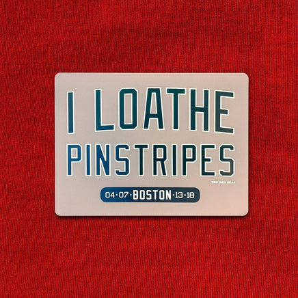 Refrigerator magnet with text 'I LOATHE PINSTRIPES' on a red background