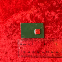 Green rectangular handmade magnet with a red square and ruler for scale