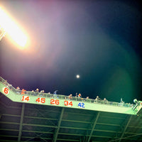 photo of right field fenway park at night with retired red sox numbers