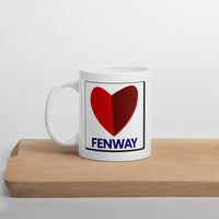 white ceramic mug with the boston fenway citgo sign in the shape of a heart on a cutting board