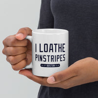 person holding 11 oz white ceramic mug with the words i loathe pinstripes in new york yankees lettering navy blue text and boston red sox world series wins