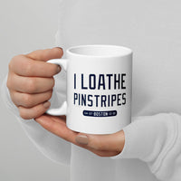 person holding 11 oz white ceramic mug with the words i loathe pinstripes in new york yankees lettering navy blue text and boston red sox world series wins