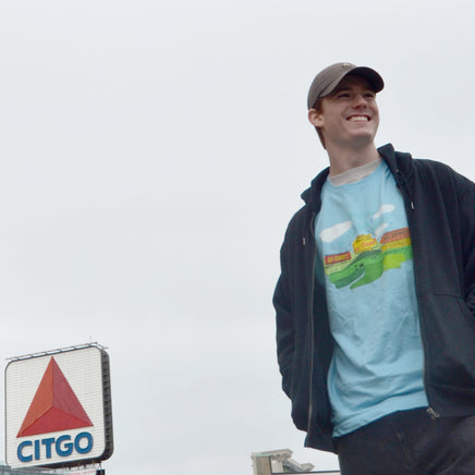 photo of man wearing Middle 8-The Red Seat sweet caroline neil diamond fenway park design on blue unisex t-shirt in front of the citgo sign