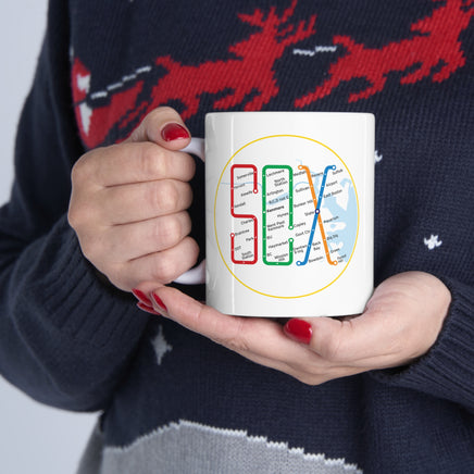 person holding white mug with design of the boston MBTA map in the shape of the word SOX