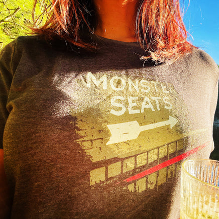 woman wearing a black t-shirt from the red seat with the fenway park green monster seats mural on it.