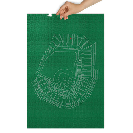 Fenway Park layout on a green background with missing pieces of a puzzle with human hand.
