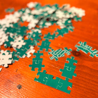 Green and white puzzle pieces on a wooden surface