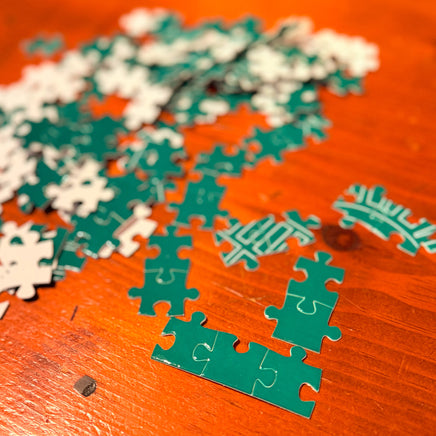 Green and white puzzle pieces on a wooden surface