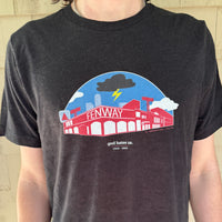 man wearing black unisex t-shirt with a red and blue design of boston red sox fenway park with a black cloud and the words "god hates us"