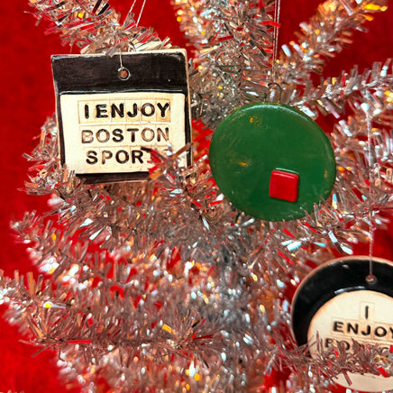 Decorative Christmas ornaments from The Red Seat on a tinsel tree with a red background