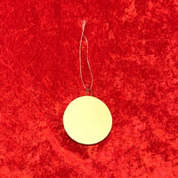 the white backside of a porcelain round christmas ornament from The Red Seat