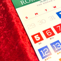 The Red Seat Calendar with colorful numbers on a red textured surface