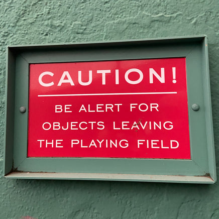 Photograph of Fenway park infield red caution warning in white text