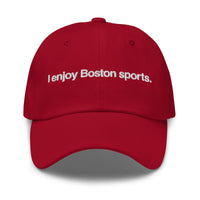 red baseball cap with "i enjoy boston sports" embroidered in white helvetica font