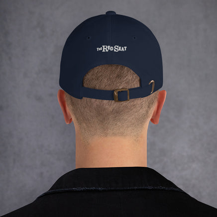 photo of the back of a man wearing a baseball hat, with the brand The Red Seat embroidered on it.