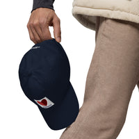 graphic of the citgo sign boston fenway as a heart embroidered on baseball hat, man holding