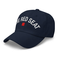 side view of navy dad cap with “The Red Seat” embroidered in white and red icon