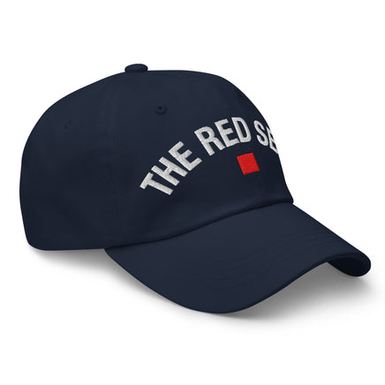 side view of navy dad cap with “The Red Seat” embroidered in white and red icon