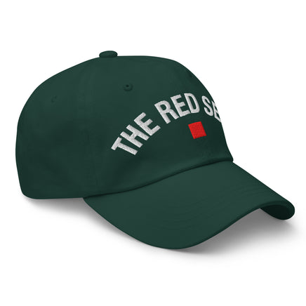side view of green dad cap with “The Red Seat” embroidered in white and red icon