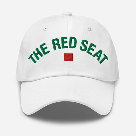 White cap with 'The Red Seat' text in green and a red square logo on a white background