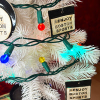 photo of white christmas tree with white and black porcelain ornaments that say, i enjoy boston sports