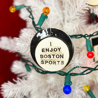 photo of white christmas tree with round white and black porcelain ornament that says, i enjoy boston sports