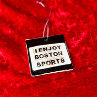 photo of square white and black porcelain ornament that says, i enjoy boston sports on red background