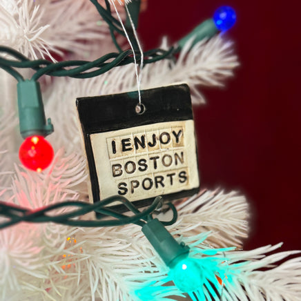 photo of white christmas tree with square white and black porcelain ornament that says, i enjoy boston sports