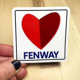 photo of a square vinyl sticker with the word FENWAY and a heart in the style of the boston citgo sign