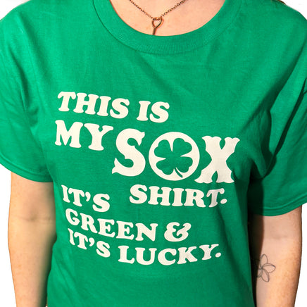 close up photo of woman wearing green unisex t-shirt from the red seat with white text that says "this is my sox shirt. it's green and it's lucky" on the front.