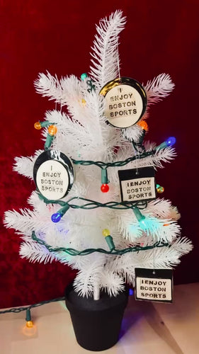 video of white christmas tree and lights with round white and black porcelain ornament that says, i enjoy boston sports and red background