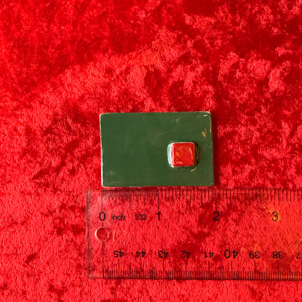Green rectangular handmade magnet with a red square and ruler for scale