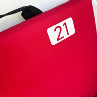 close up photo of red portable cushioned stadium seat with the number 21