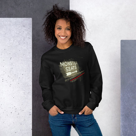 photo of woman wearing Monster Seats-The Red Seat Design with the words Monster Seats painted on a wall fenway park boston on black crewneck sweatshirt