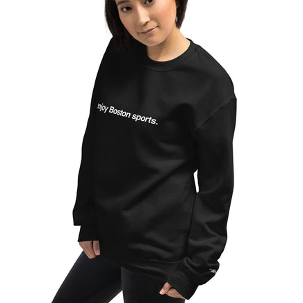 woman wearing black unisex crewneck sweatshirt with the words i enjoy boston sports in white on the front