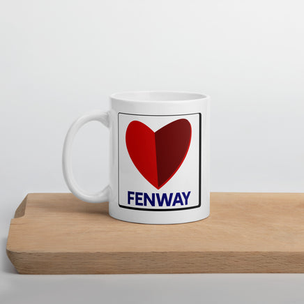 white ceramic mug with the boston fenway citgo sign in the shape of a heart on a cutting board