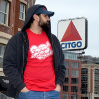 photograph of man in front  of boston citgo sign wearing spanglish red sox the red seat design white lettering on red unisex t-shirt